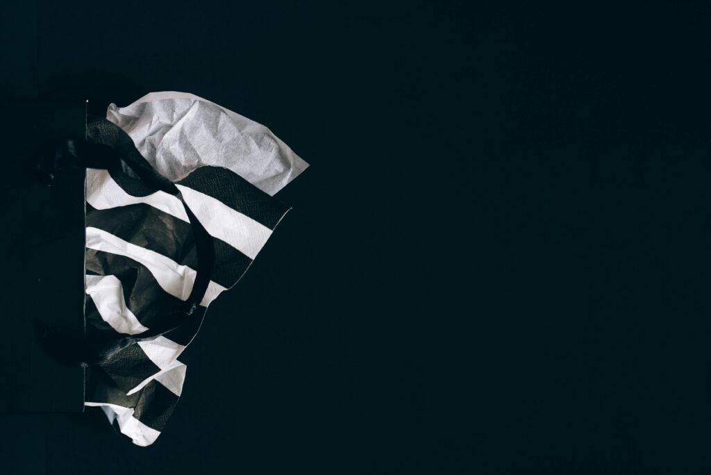 Elegant black shopping bag with white tissue paper, perfect for sale promotions.
