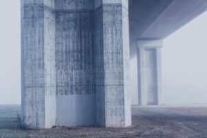pexels-photo-227729-227729 Misty view of concrete bridge columns in a foggy urban environment.